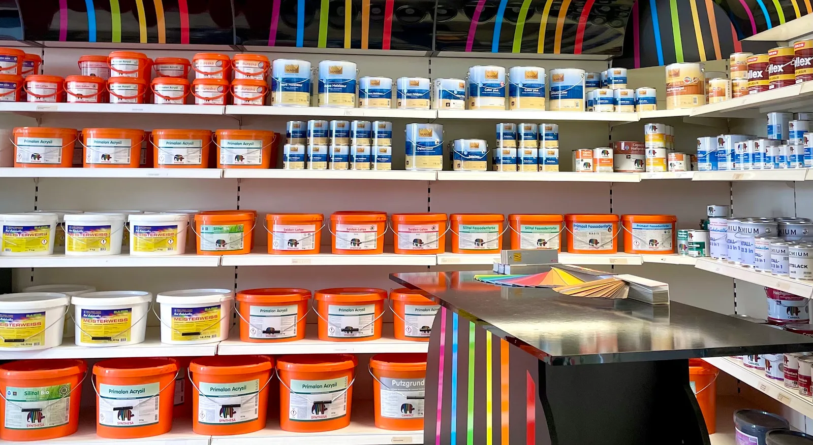 Regale mit Farben und ein geöffneter Farbfächer auf der Theke